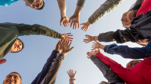 a group of people putting their hands together in the air